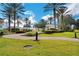 Scenic community park with lush green grass, palm trees, and a charming fountain, perfect for relaxation and recreation at 7503 Mourning Dove Cir # 101, Reunion, FL 34747