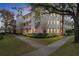 Exterior view of a bright condominium building with balconies, lush landscaping, and sidewalk in a well-maintained community at 7503 Mourning Dove Cir # 101, Reunion, FL 34747