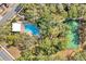 Aerial view showcasing a home with a pool, tennis court, landscaping, and a meandering footpath at 7807 Turkey Oak Ln, Kissimmee, FL 34747