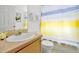 Bathroom featuring vanity with sink, mirror and toilet with a yellow and grey shower curtain at 7807 Turkey Oak Ln, Kissimmee, FL 34747