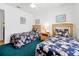 Bedroom has two beds with floral bedding, a ceiling fan, and a window with bright natural light at 7807 Turkey Oak Ln, Kissimmee, FL 34747