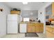 Clean kitchen featuring white appliances, light wood cabinets and tile flooring, connecting seamlessly to the living space at 7807 Turkey Oak Ln, Kissimmee, FL 34747