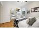 This bedroom has hardwood floors, natural light from a window, a full size mirror, and bright white colors at 8262 Bayview Crossing Dr, Winter Garden, FL 34787