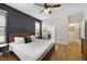 This bedroom has a decorative accent wall, wood floors, ceiling fan, and an en suite bathroom and walk-in closet at 8262 Bayview Crossing Dr, Winter Garden, FL 34787