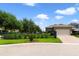 Street view of the home featuring a manicured lawn, mature trees, and a two-car garage at 8262 Bayview Crossing Dr, Winter Garden, FL 34787
