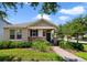 Charming single-story home with stone accents, manicured landscaping and a brick walkway leading to the front door at 8262 Bayview Crossing Dr, Winter Garden, FL 34787