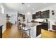 Open concept kitchen with dark cabinets, granite counters, a large island with seating and stainless appliances at 8262 Bayview Crossing Dr, Winter Garden, FL 34787