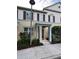 Inviting townhouse with tan siding, brown shutters, covered entryway, and landscaped front yard at 8271 Maritime Flag St # 109, Windermere, FL 34786