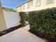Home exterior featuring a concrete walkway, white fence, and lush green shrubs at 8271 Maritime Flag St # 109, Windermere, FL 34786