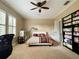 This carpeted bedroom has a ceiling fan, white plantation shutters, and a bookshelf for storage at 907 Pawstand Rd, Celebration, FL 34747