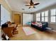 Cozy bedroom featuring a daybed, a ceiling fan, and large bright windows with white shutters at 907 Pawstand Rd, Celebration, FL 34747