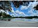 Picturesque lakeside view with comfortable chairs under green umbrellas, reflecting the sky and clouds above at 907 Pawstand Rd, Celebration, FL 34747