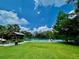 Outdoor tennis court surrounded by lush green trees and a picnic area on a beautiful sunny day at 907 Pawstand Rd, Celebration, FL 34747