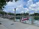Scenic view of the lake and park from a concrete walkway with patriotic flags hanging from the railing at 907 Pawstand Rd, Celebration, FL 34747
