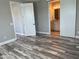 Neutral bedroom boasts wood-look flooring, bathroom access, and natural light at 9938 Eagle Creek Center Blvd, Orlando, FL 32832