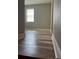 A bright bedroom featuring modern wood flooring and natural light from a window at 9938 Eagle Creek Center Blvd, Orlando, FL 32832