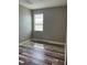 A well-lit bedroom featuring durable wood flooring and a window with ample natural light at 9938 Eagle Creek Center Blvd, Orlando, FL 32832
