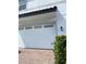 Spacious white garage with brick driveway and a decorative light fixture, enhancing the home's functionality at 9938 Eagle Creek Center Blvd, Orlando, FL 32832