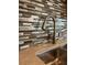 Close-up of a modern kitchen faucet paired with a stylish backsplash and granite counter at 9938 Eagle Creek Center Blvd, Orlando, FL 32832