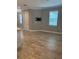 Bright living room featuring wood-look tile floors and a mounted TV, offering a modern and comfortable space at 9938 Eagle Creek Center Blvd, Orlando, FL 32832