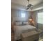 The spacious bedroom has an upholstered bed with a ceiling fan and hardwood floors at 9938 Eagle Creek Center Blvd, Orlando, FL 32832