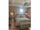 The spacious bedroom has an upholstered bed with matching lamps, a ceiling fan and hardwood floors at 9938 Eagle Creek Center Blvd, Orlando, FL 32832