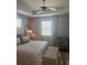 The spacious bedroom has an upholstered bed with a ceiling fan and hardwood floors at 9938 Eagle Creek Center Blvd, Orlando, FL 32832
