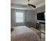 The spacious bedroom has a TV with a chair, a ceiling fan and hardwood floors at 9938 Eagle Creek Center Blvd, Orlando, FL 32832