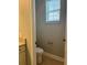 Compact powder room features a toilet and window at 9938 Eagle Creek Center Blvd, Orlando, FL 32832