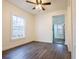 Bedroom with a ceiling fan and gray wood floors looking toward the kitchen at 1007 11Th St, St Cloud, FL 34769