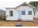 Quaint single-story home with a light blue front door, freshly painted white exterior, and new landscaping at 1007 11Th St, St Cloud, FL 34769