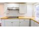 Bright kitchen features white cabinets, butcher block countertops, and a modern cooktop at 1007 11Th St, St Cloud, FL 34769