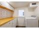 Bright laundry area features a washer, butcher block countertops, and white cabinets at 1007 11Th St, St Cloud, FL 34769