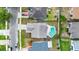 Aerial view of a home with a backyard swimming pool, fenced in yard, concrete driveway, and shingled roof at 1050 Dees Dr, Oviedo, FL 32765