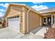 Side view of a beige home highlighting the two-car garage and the front porch at 1050 Dees Dr, Oviedo, FL 32765