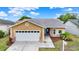 Charming one-story home with a well-manicured lawn, a paved walkway, and an attached two-car garage at 1050 Dees Dr, Oviedo, FL 32765
