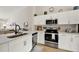 Bright, modern kitchen with white cabinets, stainless steel appliances, and a sleek sink area perfect for cooking and entertaining at 1050 Dees Dr, Oviedo, FL 32765