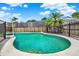 Backyard pool with safety fence surrounded by mature trees and landscaping at 1050 Dees Dr, Oviedo, FL 32765