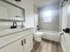 Bathroom showcasing a white vanity, marble tiled shower, and wood-look flooring at 1098 Leeway Ct, Orlando, FL 32810