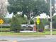 Entrance sign to Kingswood Manor with landscaped surroundings and traffic control signals at 1098 Leeway Ct, Orlando, FL 32810