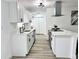 Modern white kitchen featuring stainless steel appliances, black accents, and wood-look flooring at 1098 Leeway Ct, Orlando, FL 32810