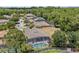Overhead shot showcases the property's location surrounded by lush greenery and neighboring houses at 1103 Cypress Pointe Blvd, Davenport, FL 33896