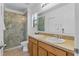Bright bathroom featuring double sinks, granite countertops, and a glass-enclosed shower at 1103 Cypress Pointe Blvd, Davenport, FL 33896