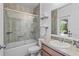 Well-lit bathroom featuring shower and bathtub combination, sink, and sliding glass shower doors at 1103 Cypress Pointe Blvd, Davenport, FL 33896