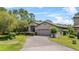 Inviting single-story home featuring a well-manicured lawn and a brick driveway at 1103 Cypress Pointe Blvd, Davenport, FL 33896