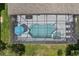 Aerial view of a screened-in pool with an umbrella and lounge chairs, providing a private outdoor oasis at 1103 Cypress Pointe Blvd, Davenport, FL 33896
