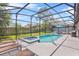 A screened-in pool with hot tub, patio space, and a well-manicured backyard at 1103 Cypress Pointe Blvd, Davenport, FL 33896