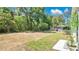 Large backyard area is grassy and green and surrounded by mature trees at 118 Deacon Jones Blvd, Orlando, FL 32810