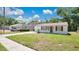 Inviting single-story home featuring a lush green lawn, with an extended driveway and cozy carport at 118 Deacon Jones Blvd, Orlando, FL 32810