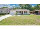 Charming single-story home with a well-maintained lawn, refreshed white paint, and a cozy carport at 118 Deacon Jones Blvd, Orlando, FL 32810